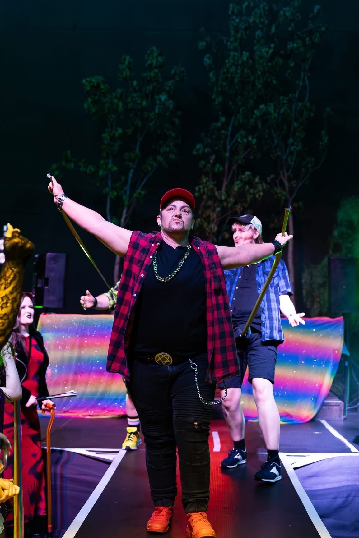 A drag king holding tape measures. 