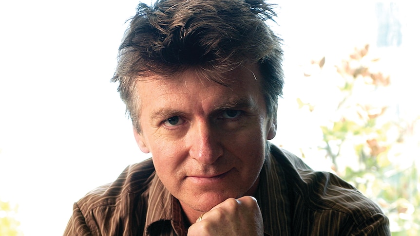 Musician Neil Finn with chin on hand looking directly at camera