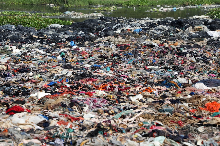 A mountain of clothes thrown into a river.