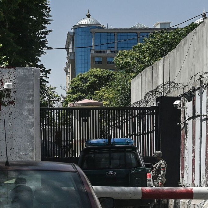 A security guard checks cars at the heavily fortified and monitored entrance to the now-closed embassy compound in Kabul
