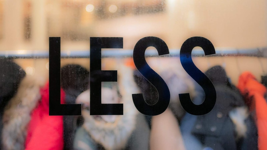 'LESS' pictured on the window of a clothing retailer