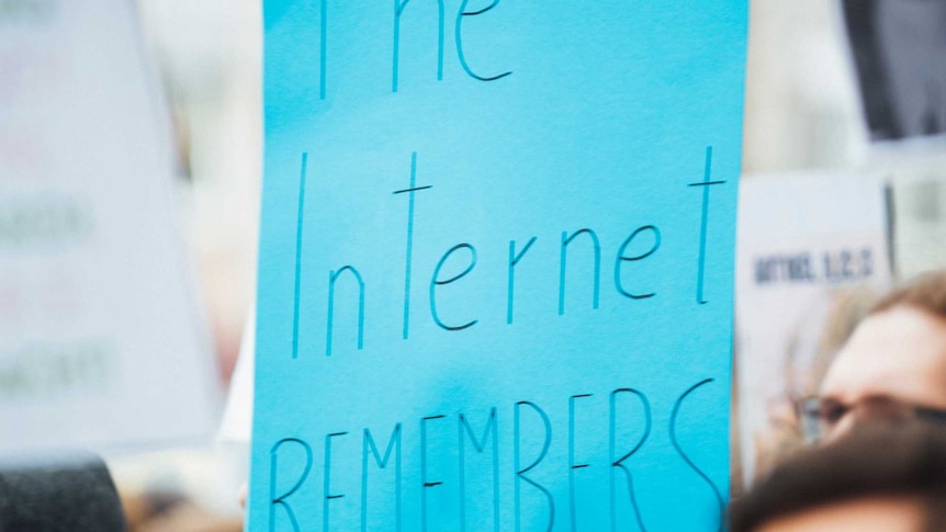 hand holding up sign: the internet remembers