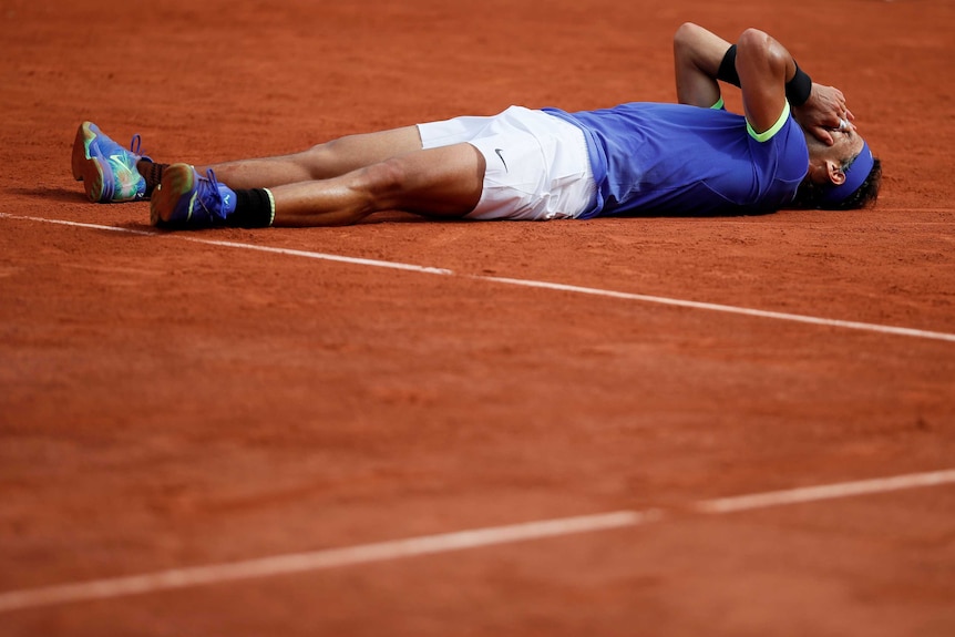 Rafael Nadal falls to the ground after clinching victory against Stan Wawrinka in straight sets.