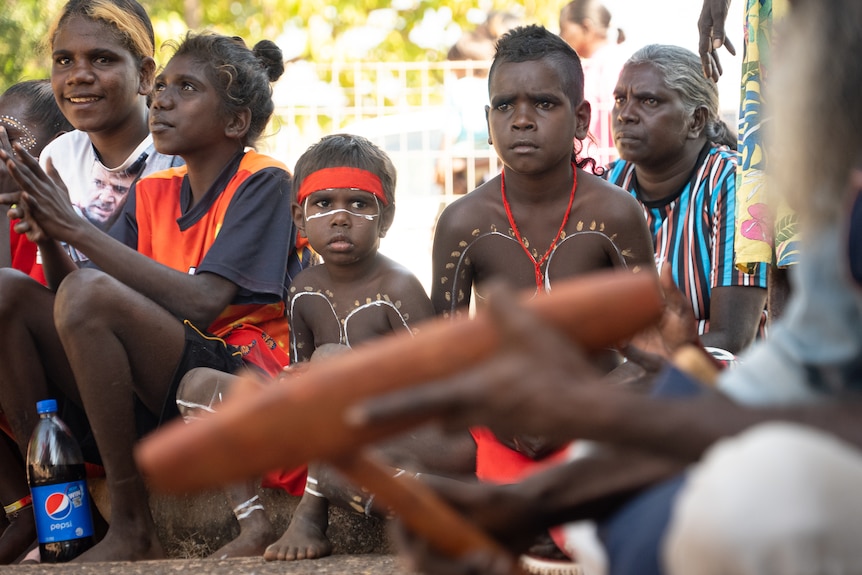 Community members perform ceremony outside Wadeye’s supermarket. 