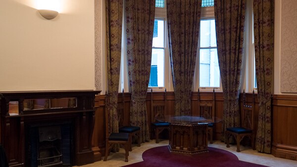 A quiet corner of the boardroom, with round table and fireplace.