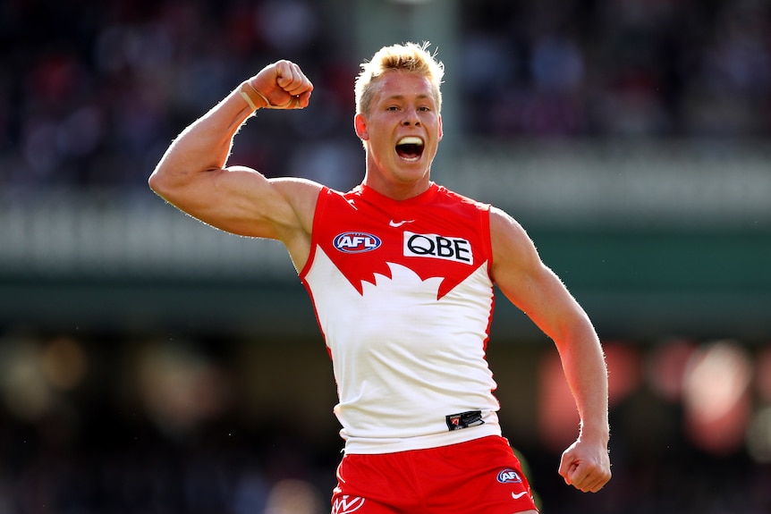 A Sydney Swans AFL forward pumps his fist and calls out in celebration after kicking a goal.