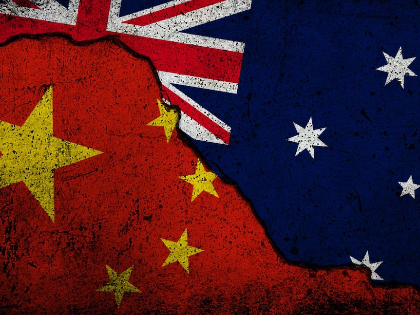 A piece of land with the Australian flag and the Chinese flag next to each other with a big crack separating the two