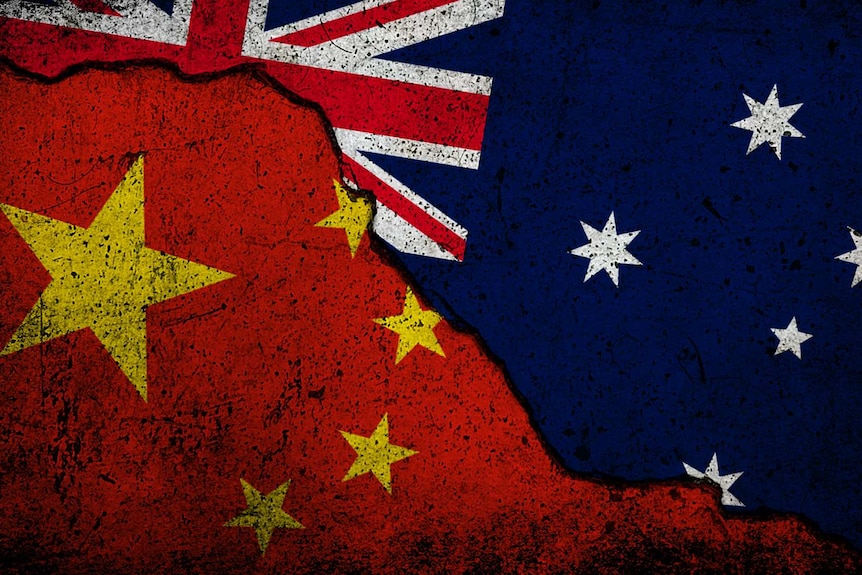 A piece of land with the Australian flag and the Chinese flag next to each other with a big crack separating the two