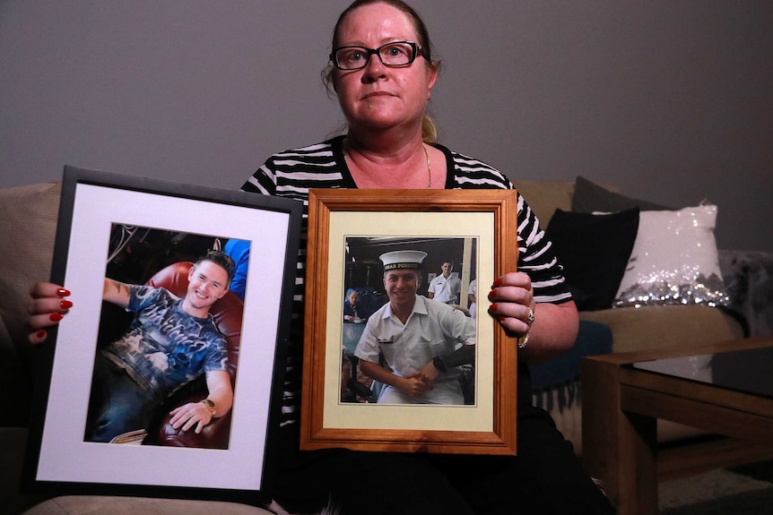 Donna Anderson holding framed photos of her two sons.