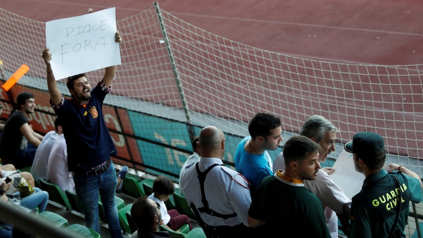 Spain fan holds sign while heckling Gerard Pique