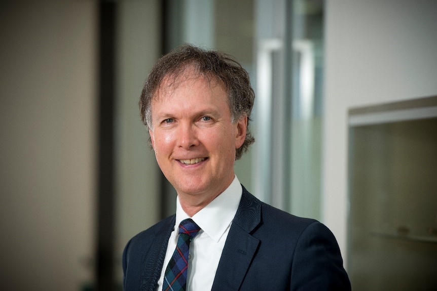 man with shirt, tie and blazer smiling for the camera