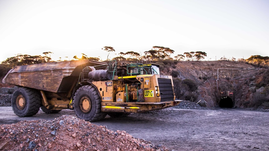 Mining truck with underground portal in background
