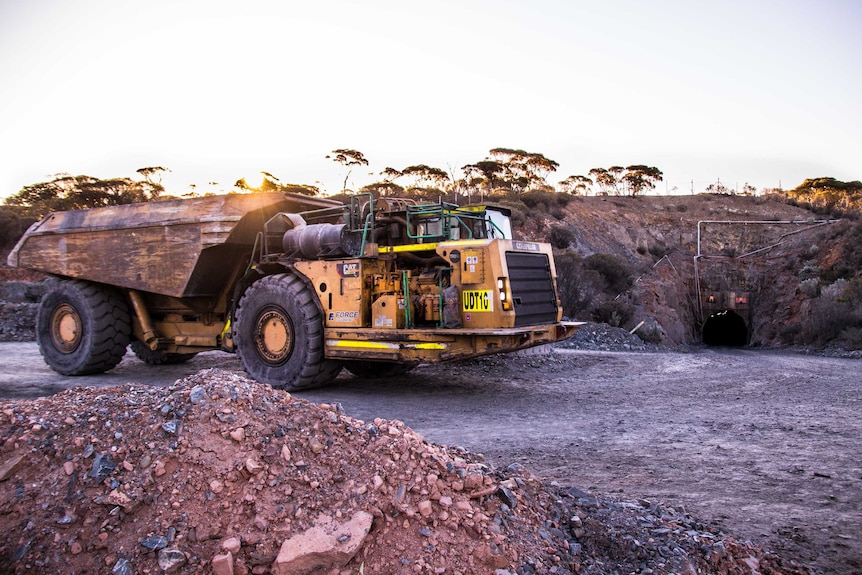 Mining truck with underground portal in background