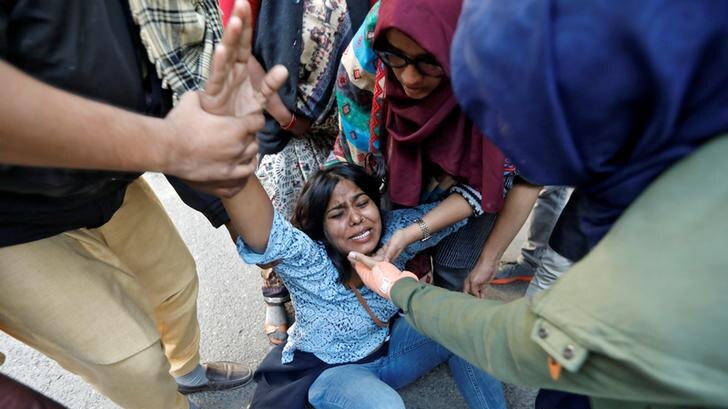 A woman on the floor in tears after she was injured during a protest against a new citizenship law