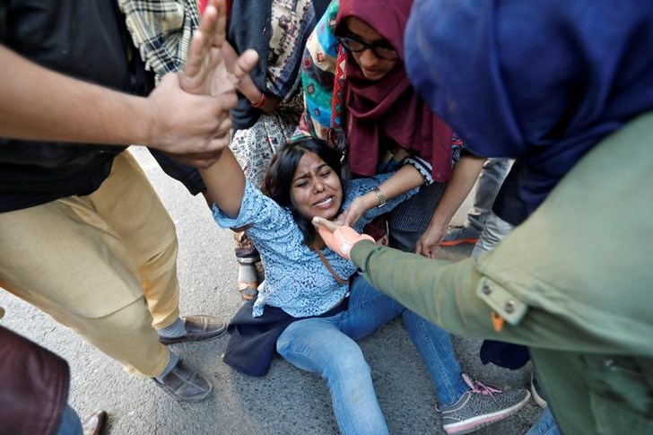 A woman on the floor in tears after she was injured during a protest against a new citizenship law