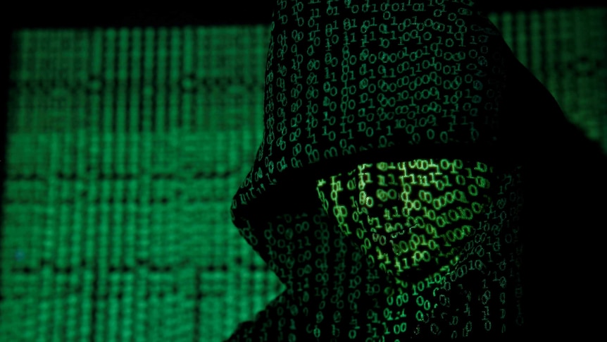 A projection of cyber code on a hooded man is pictured in this illustration picture taken on May 13, 2017.