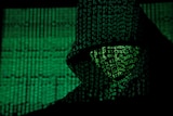 A projection of cyber code on a hooded man is pictured in this illustration picture taken on May 13, 2017.