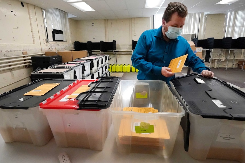 An election official prepares absentee and early vote ballots to be sent for counting on election day.