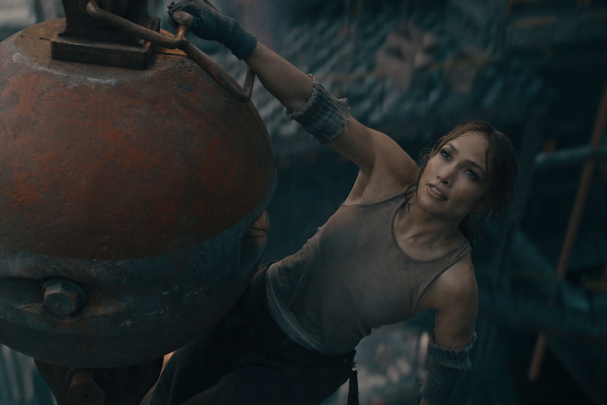 Jennifer Lopez appears to be swinging from a wrecking ball inside a factory in still from movie.
