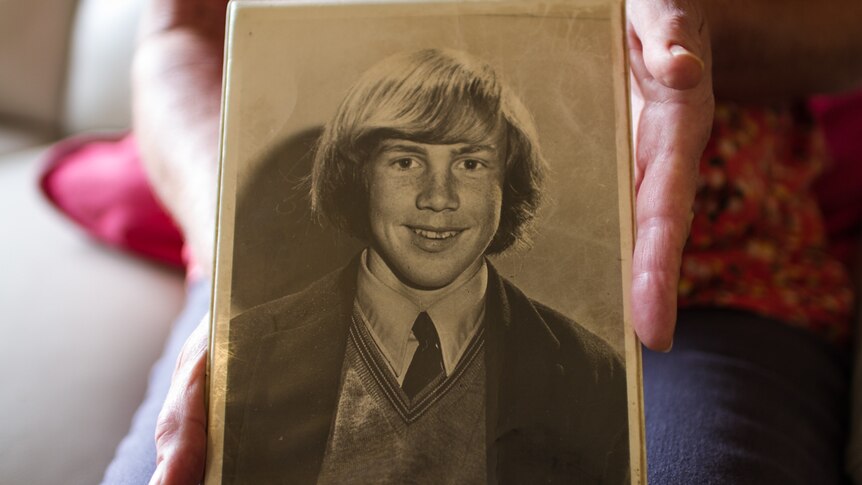 Rachel's hands holding an iold black and white phot of her brother Don.