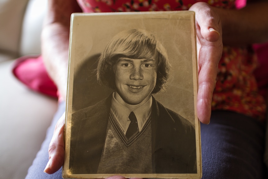 Rachel's hands holding an iold black and white phot of her brother Don.