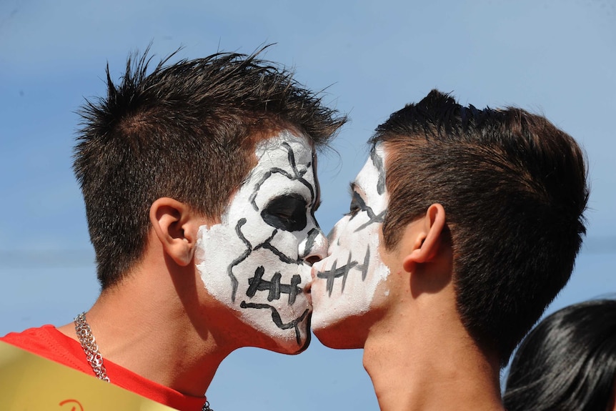 Young gay men kiss at a rally against homophobia
