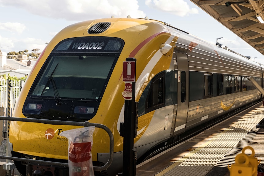 Un train jaune stationné sur les voies