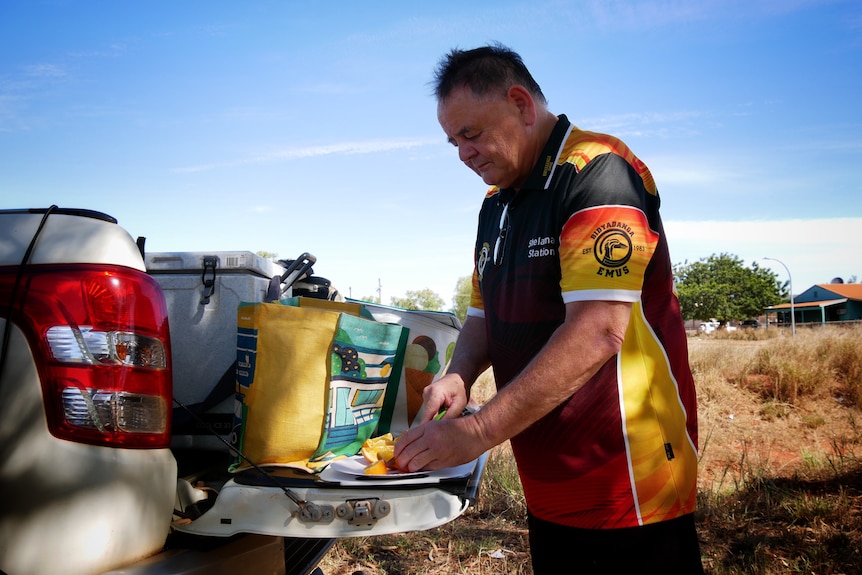 Nurse Latham Rogers preparing food on a ute in Bidyadanga June 2022. 