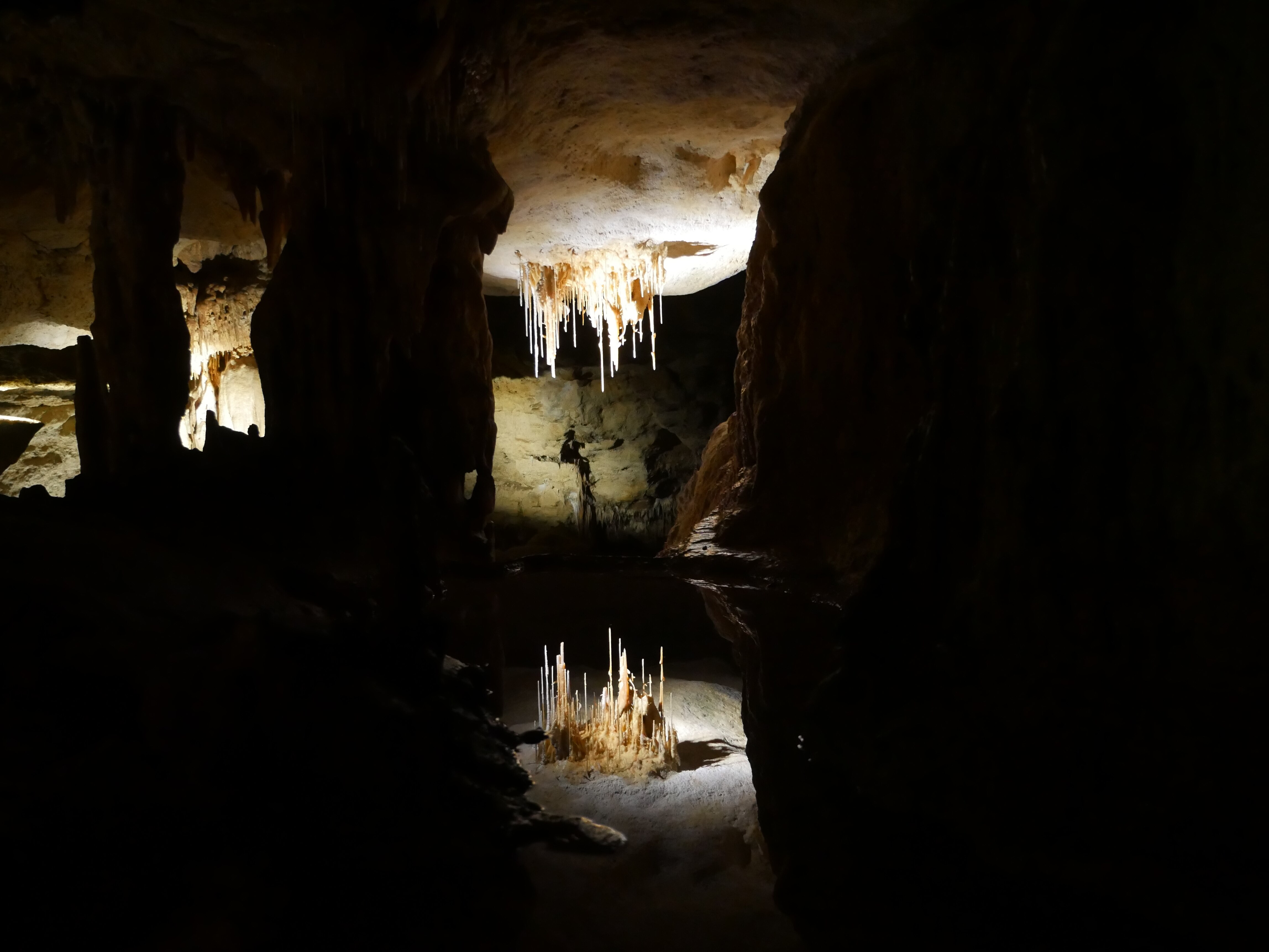 A water reflection pool showing a mirror image of a cave roof. 