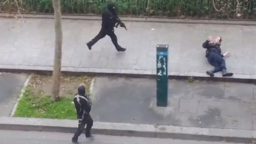 Injured police officer Ahmed Merabet on the ground outside the Charlie Hebdo office, as masked gunmen approach.