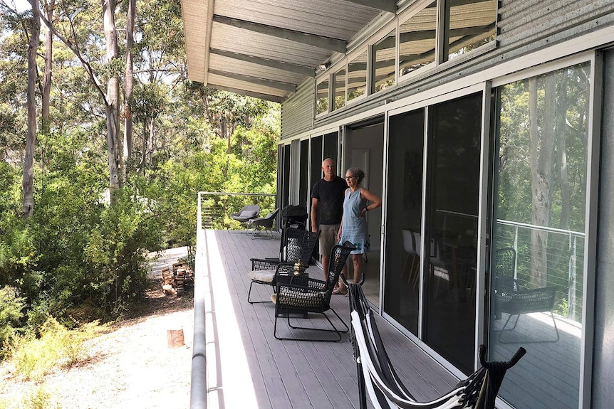 Shauna and Michael Ausma stand on the front verandah of their Karri Fire House in Western Australia.