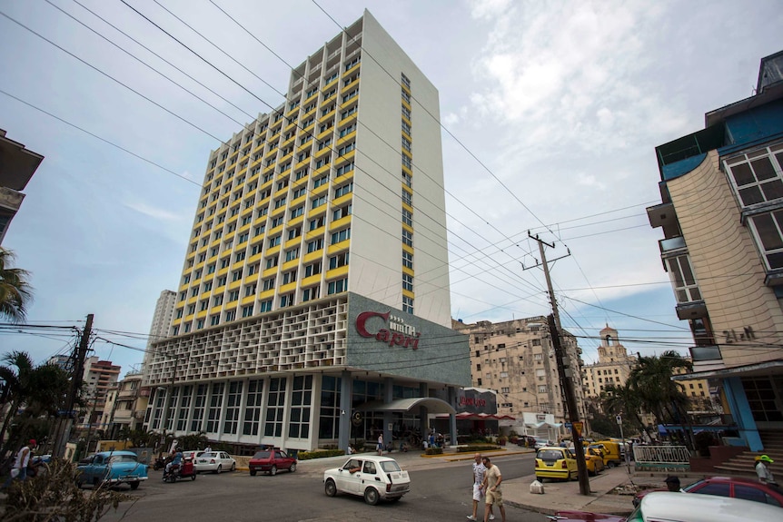 Exterior shot of Hotel Capri with cars parked outside.