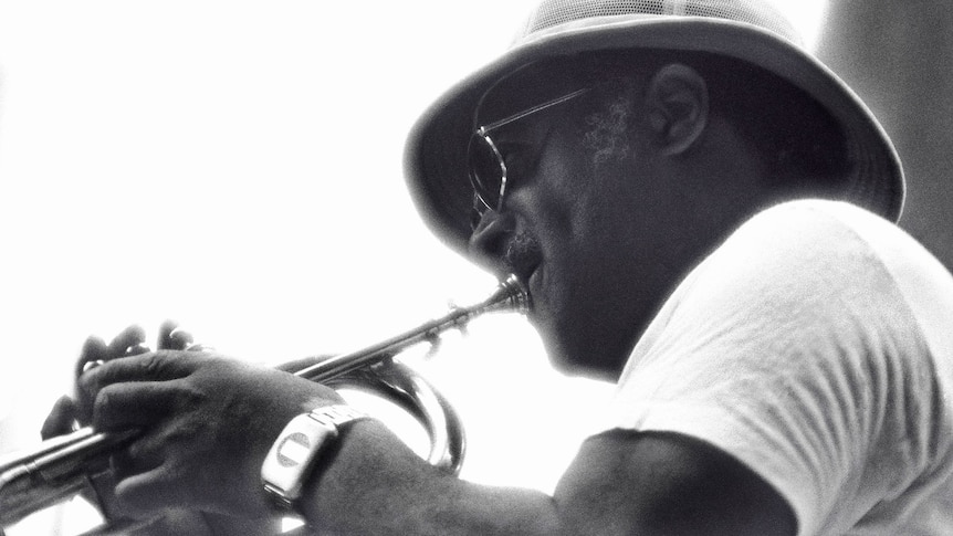 Clark Terry blowing his horn and wearing a safari hat