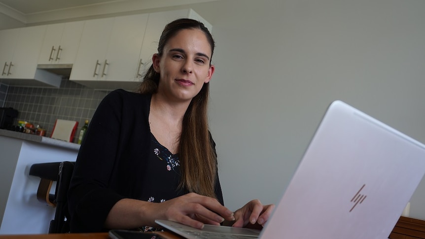 A young woman tries to buy tickets to an event on her laptop