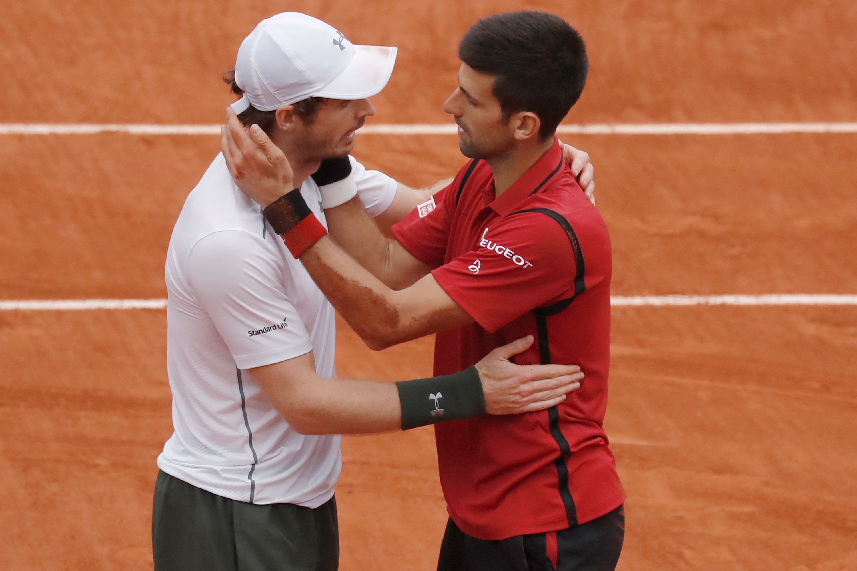 Andy Murray and Novak Djokovic hugging on a clay court