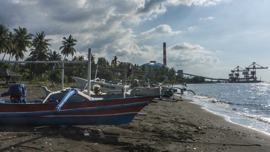 Boats rest on a beach near the The Celukan Bawan power station.