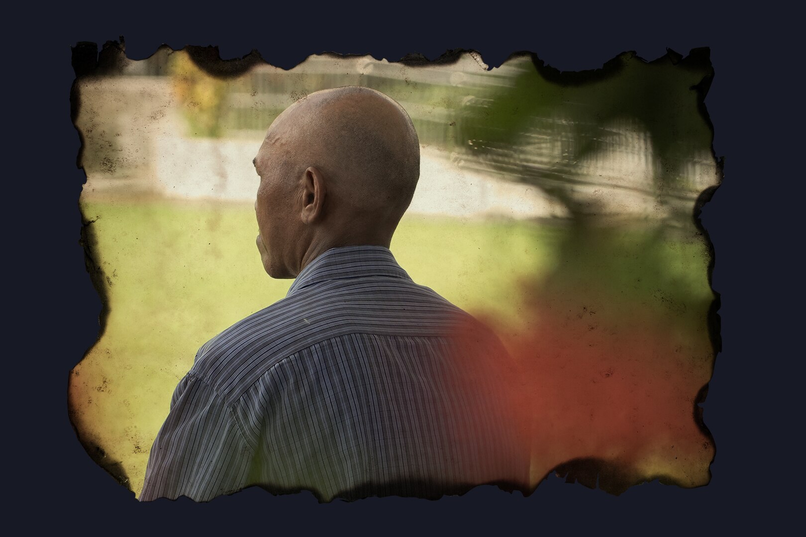 An edited photo with the edges burned featuring the back of a bald man's head.