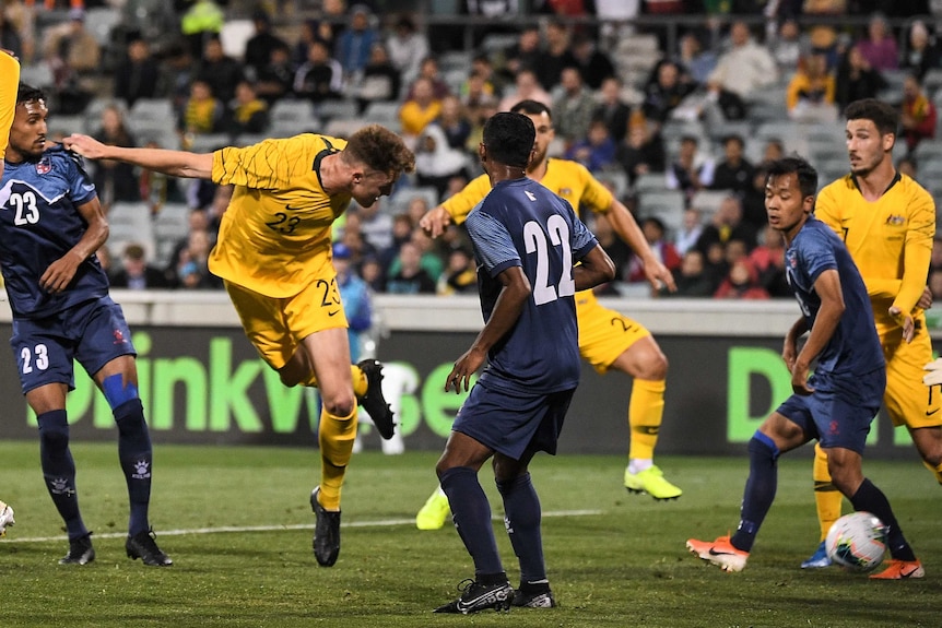 A tall, gangly footballer stoops to head the ball into the net for a goal in a World Cup qualifier.