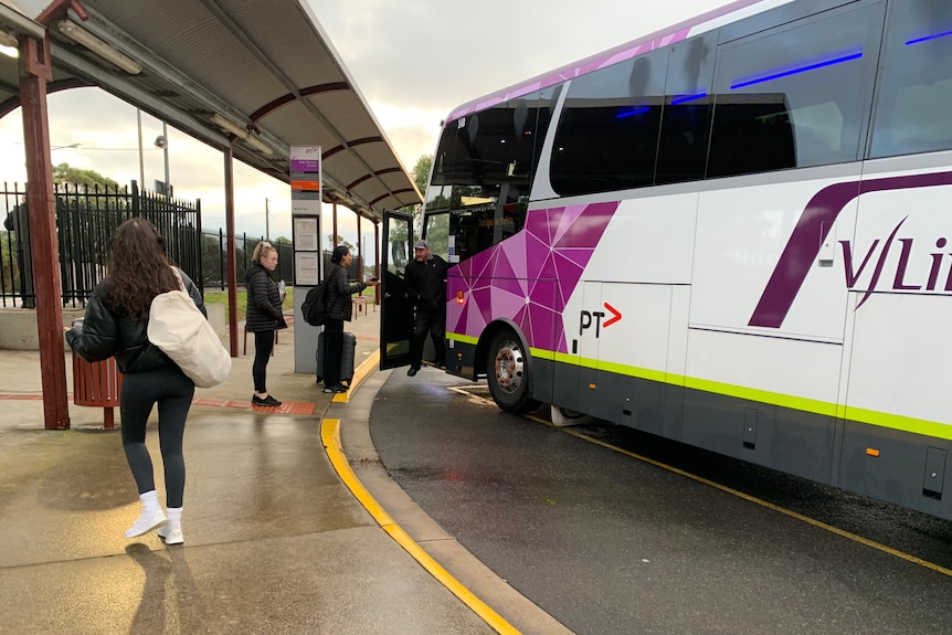 a v/line coach with people lined up to get aboard.