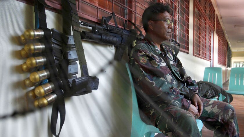 Polls open: A soldier sits outside a voting centre in Manila