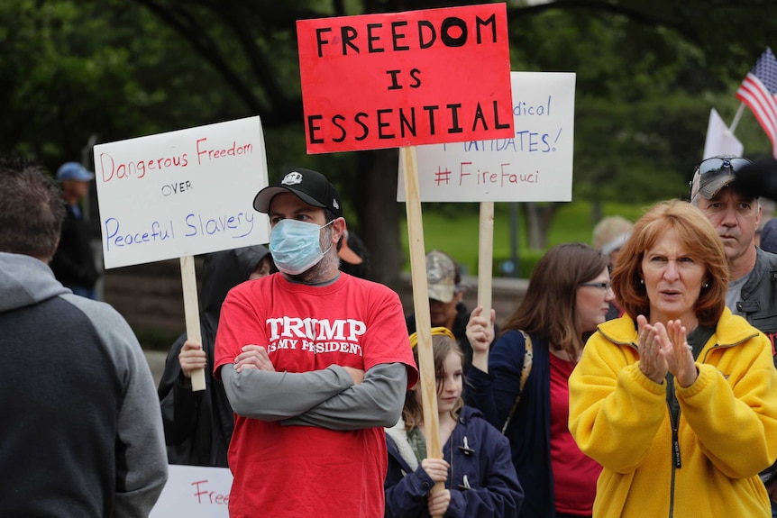 People protest in Austin, Texas carrying placards for the reopening of the country.