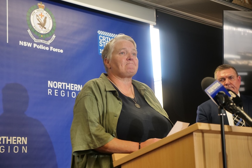 Roslyn Reay's daughter Mandii holds a photo of her mother while addressing the media at Newcastle Police Station.