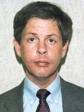 A mugshot of a man in a suit and tie