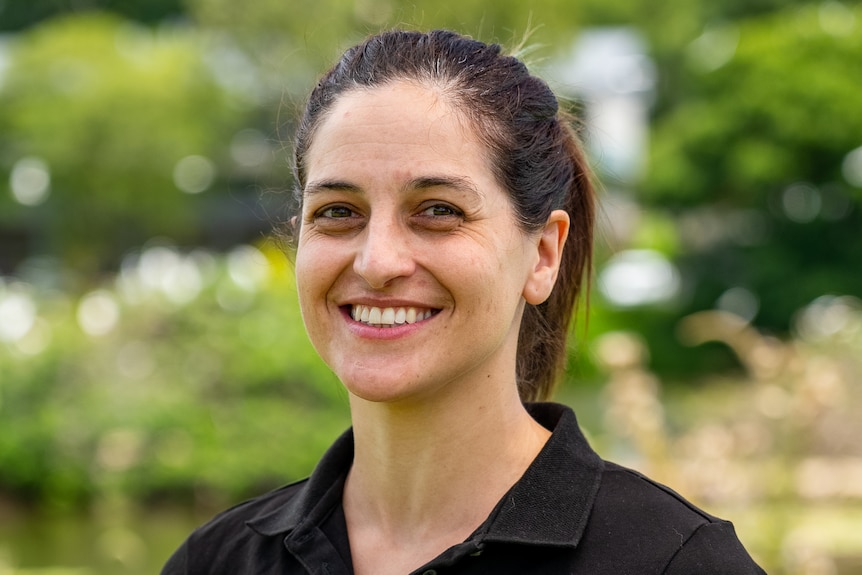 Professional photo of young white woman with brown hair in UniSC work shirt.