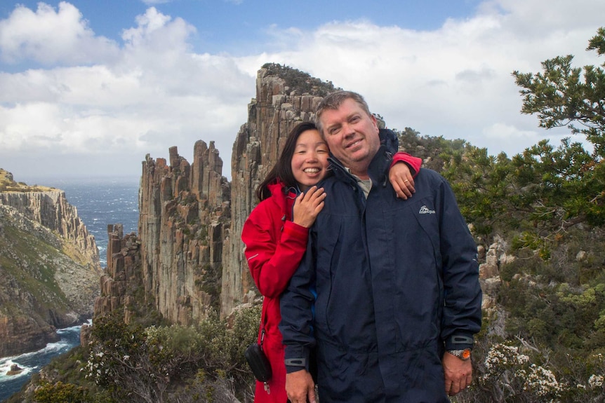 Geoff and Hwee Carter on a cliff overlooking the ocean