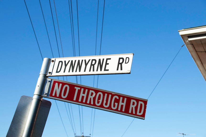 Una señal de tráfico que dice Dynnyrne Road y n0o through road.