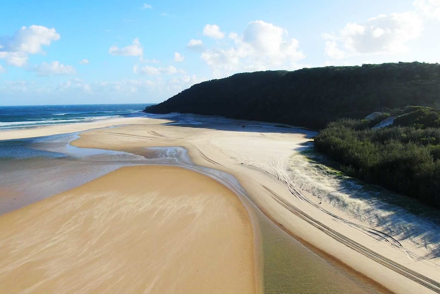 An aerial shot of a beach with blue sky.