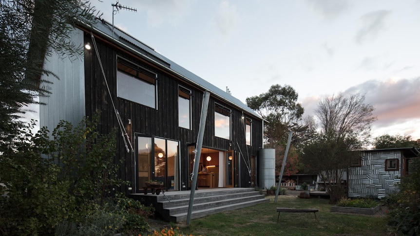 The back view of a two-storey house, featuring charred timber cladding.