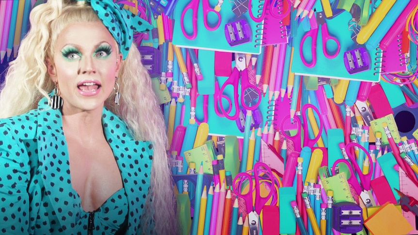 Courtney Act on the left, notebooks, pens and pencils in the background