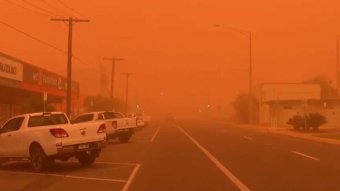 Cars are parked in the main street of Mildura's CBD as an orange haze totally fills the sky, lowering visibility significantly.